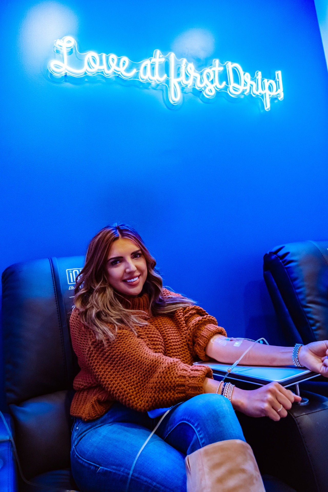 iCRYO Boca Raton guest receiving an IV drip under the Love at First Drip neon